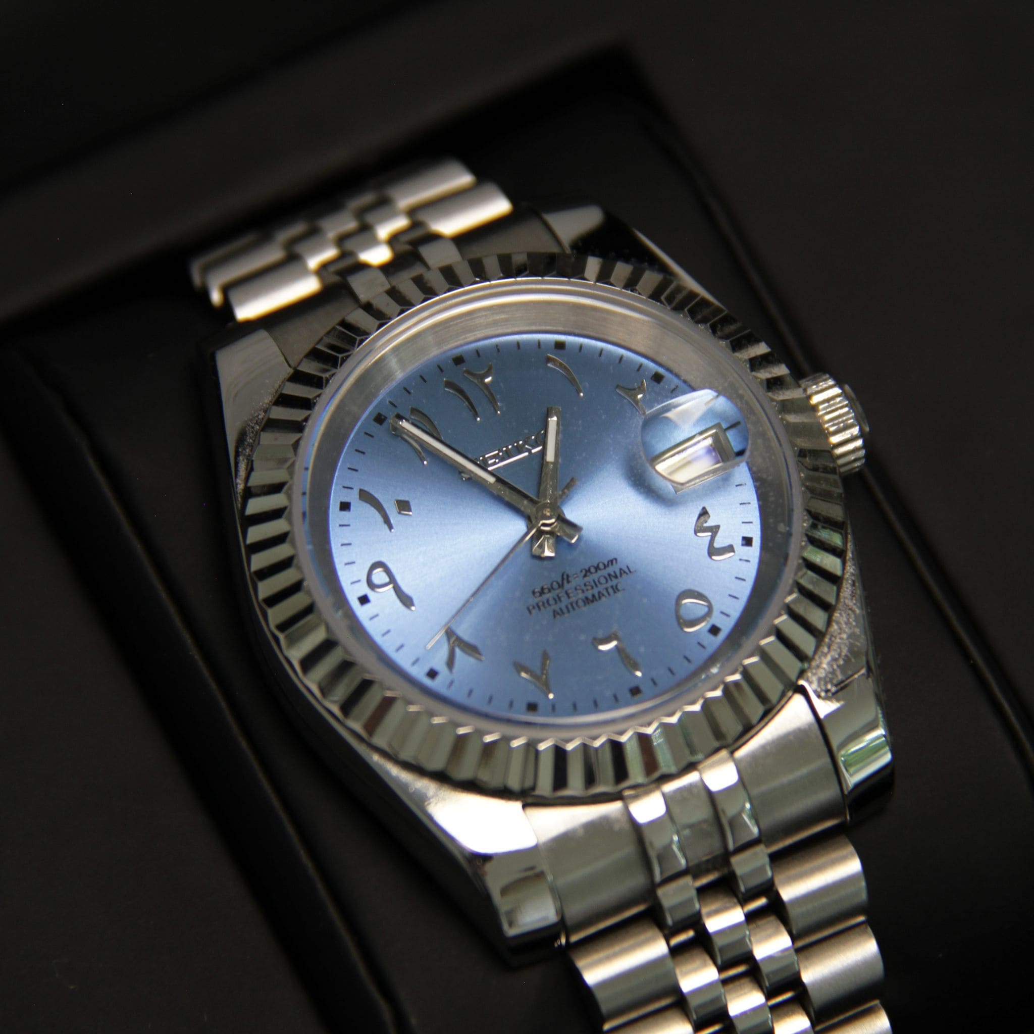 Montre Modus seiko datejust arabic bleu sur coussin noir dans écrin Modus seiko