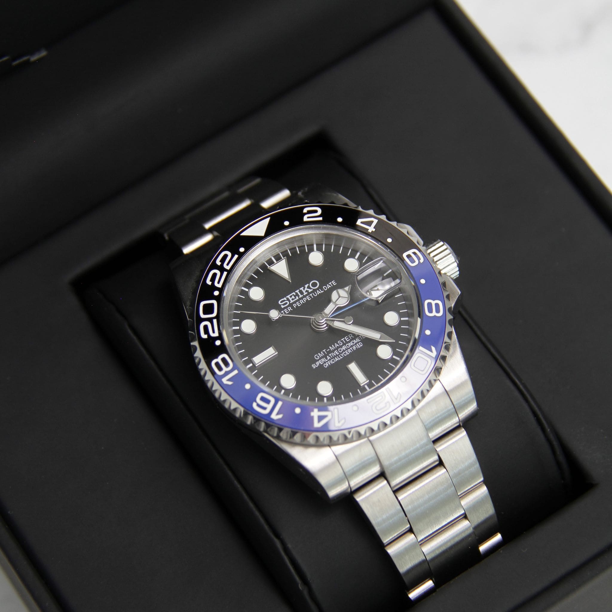 Montre Seiko Mod gmt Batman en gros plan sur coussin noir