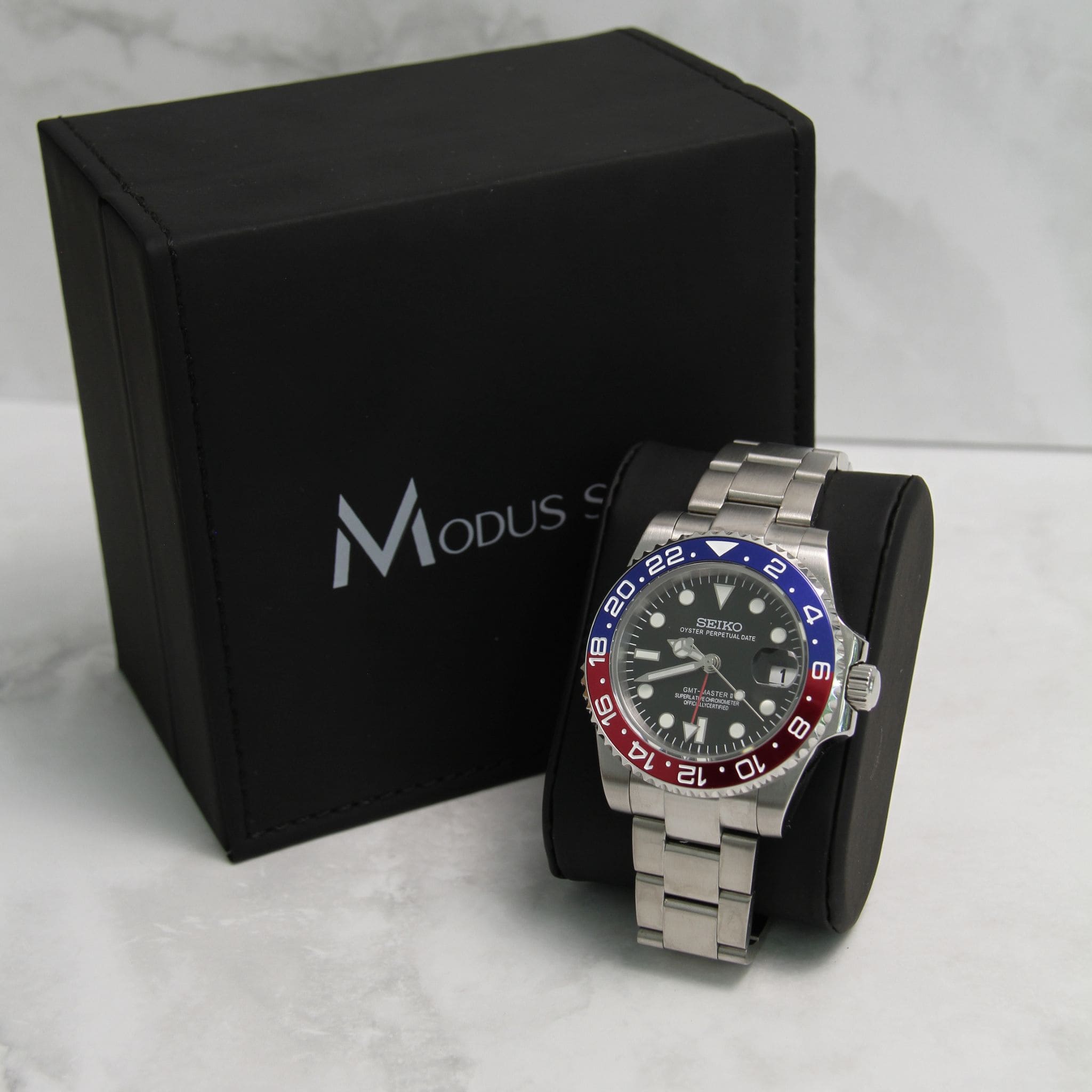 Montre Modus seiko gmt Pepsi sur coussin noir avec écrin Modus seiko.