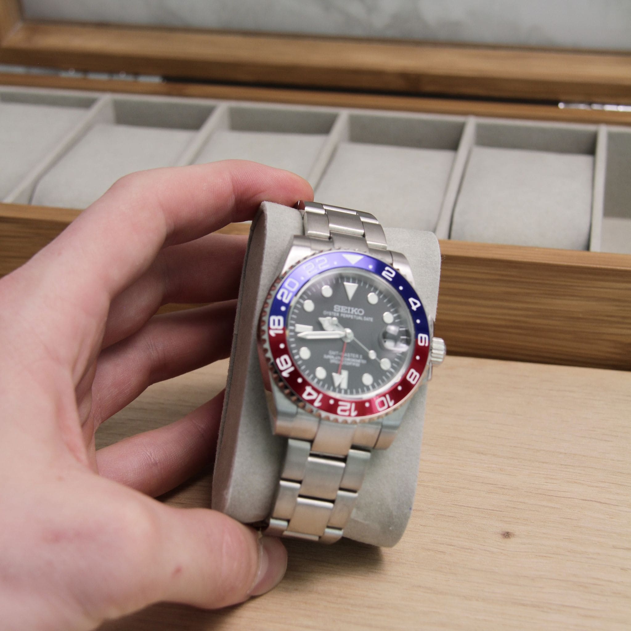 Montre Seiko mod gmt pepsi vu de face sur coussin.