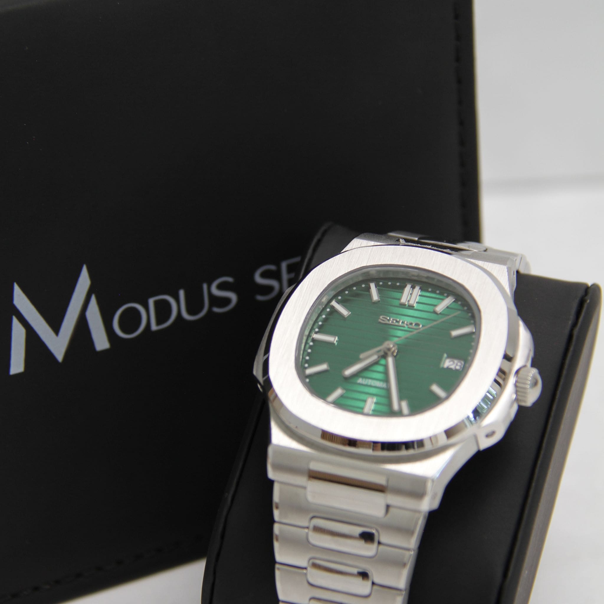 Montre Seiko mod nautilus vert vu de face sur coussin