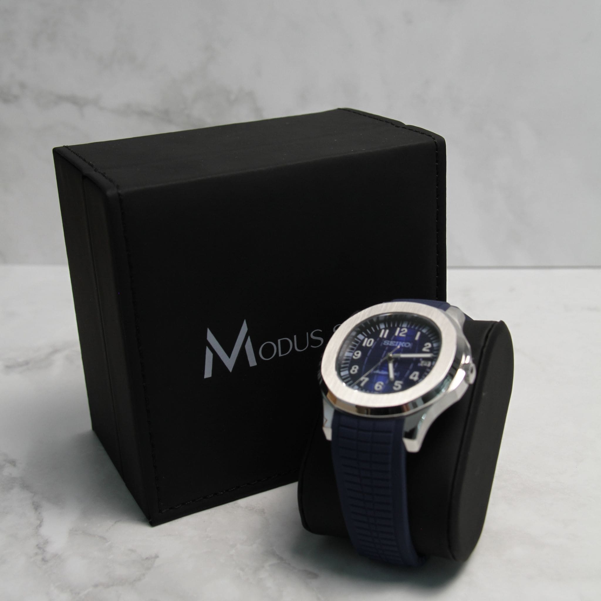 Montre Seiko Mod aquanaut bleu sur coussin noir avec écrin en arrière plan