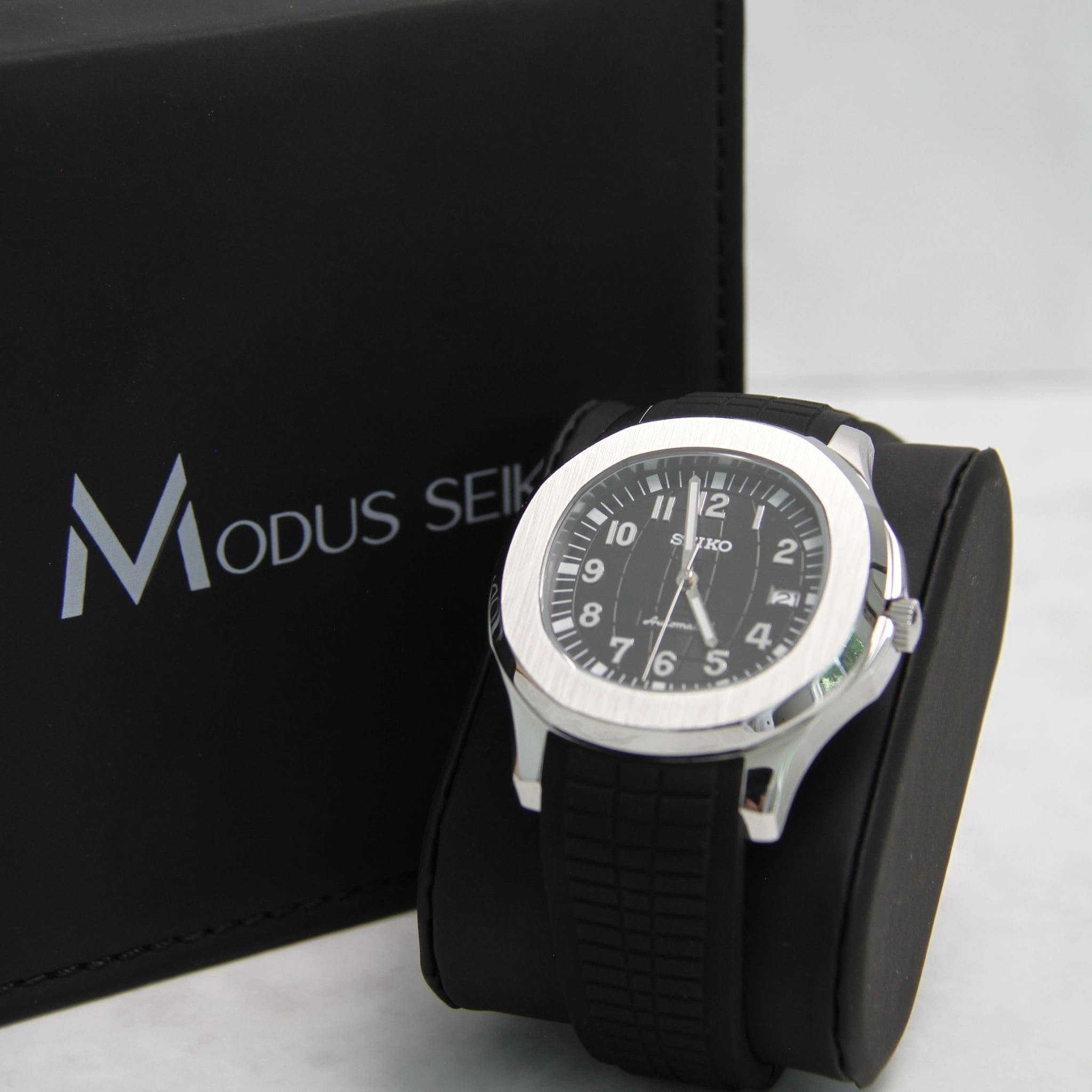 Montre Seiko mod aquanaut noir vu de face sur coussin. 