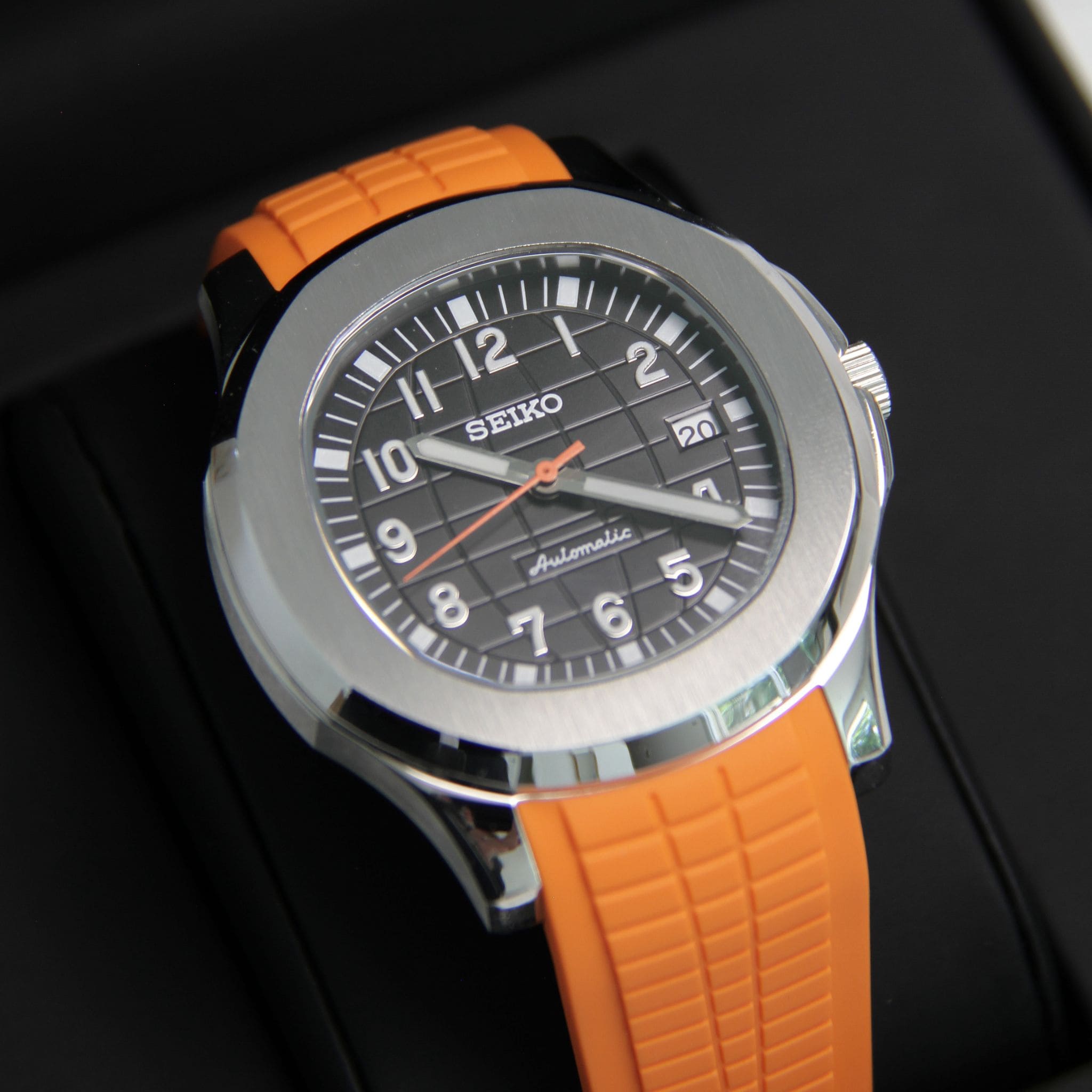 Montre Seiko mod aquanaut orange vu de face sur coussin.